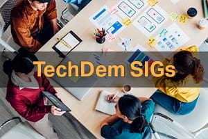 Click here to explore the TechDem SIGs. Image: A group collaborating at a large table. 