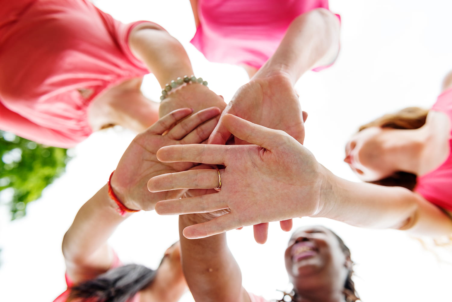Closeup of diverse women join hands together teamwork